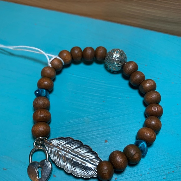 Wood bead bracelet with feather and heart lock. Stretchy one size boho vibe. - Picture 5 of 7